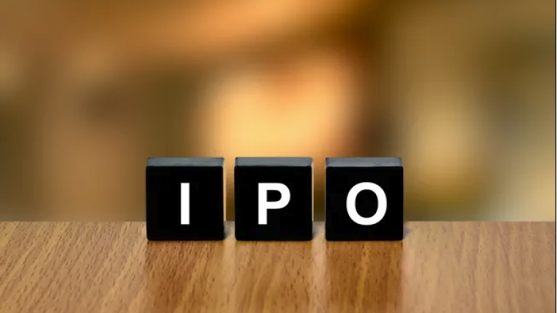 Three black letter tiles on a wooden table spell 'IPO' with a blurred warm background.